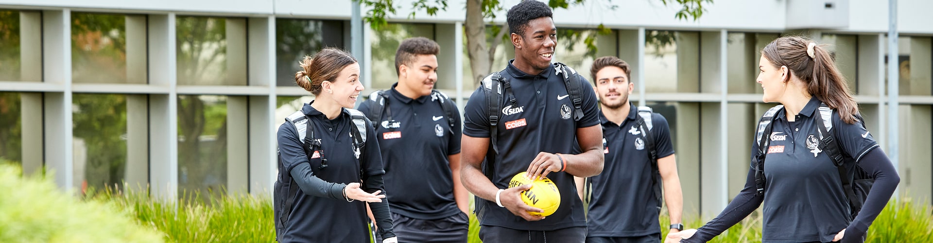A group of Collingwood Magpies Sport & Business Program students walking together and laughing